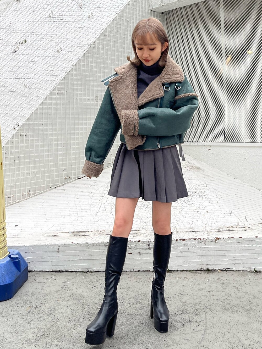 グレー系のスカート、グレー系のTシャツ/カットソー、ホワイト系のブーツを着用したレディースの秋コーディネートの3枚目の写真