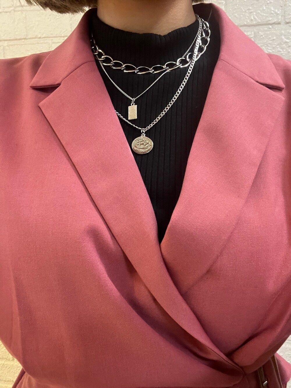 ブラック系のブーツ、ブラック系のショルダーバッグ、ピンク系のワンピースを着用したレディースの冬コーディネートの7枚目の写真