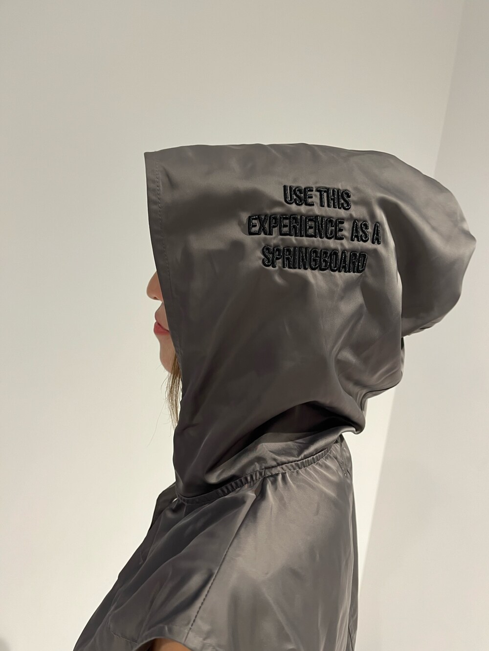 シルバー系のブーツ、グレー系のベスト、ホワイト系のスカートを着用したレディースの夏コーディネートの6枚目の写真