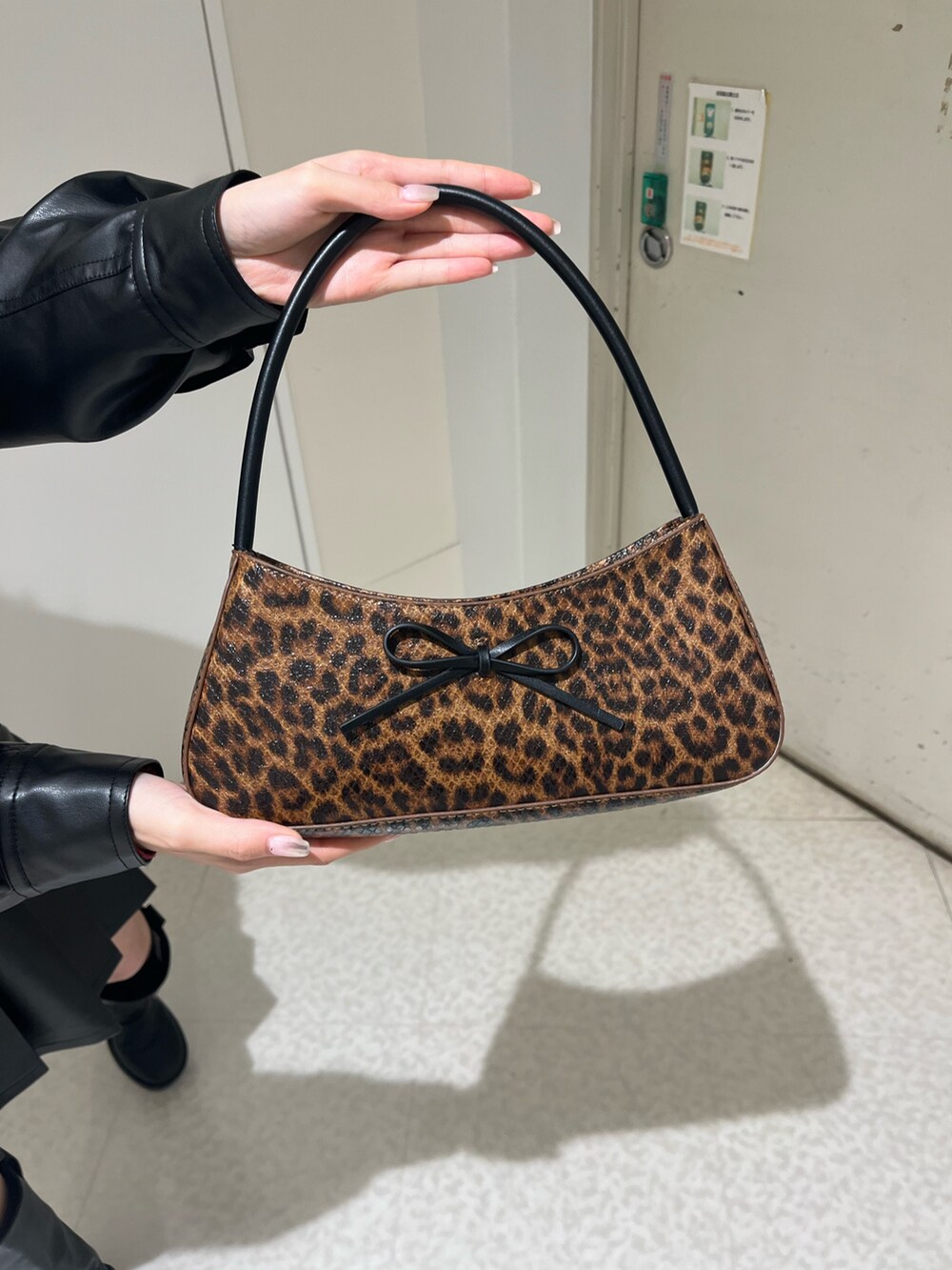 ブラウン系のブルゾン、ブラウン系のスカート、ブラウン系のハンドバッグを着用したレディースの春コーディネートの5枚目の写真