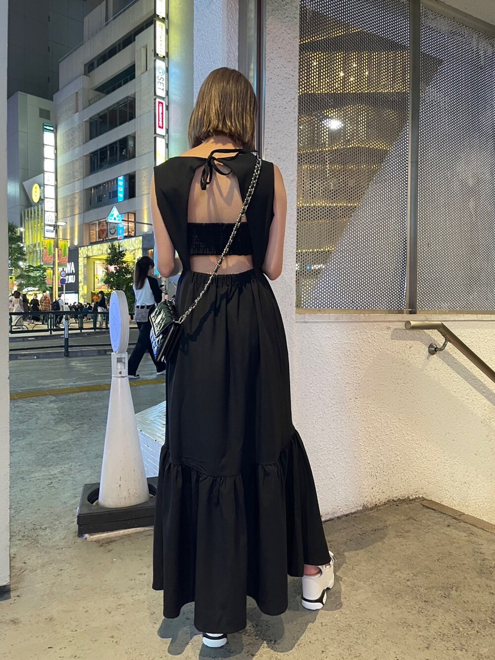 ブラック系のワンピース、ブラック系のショルダーバッグ、ホワイト系のサンダルを着用したレディースの夏コーディネートの6枚目の写真