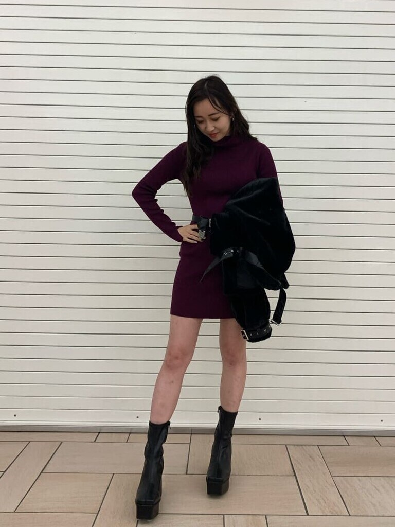その他のハンドバッグ、パープル系のワンピース、ブラック系のブーツを着用したレディースの秋コーディネートの2枚目の写真
