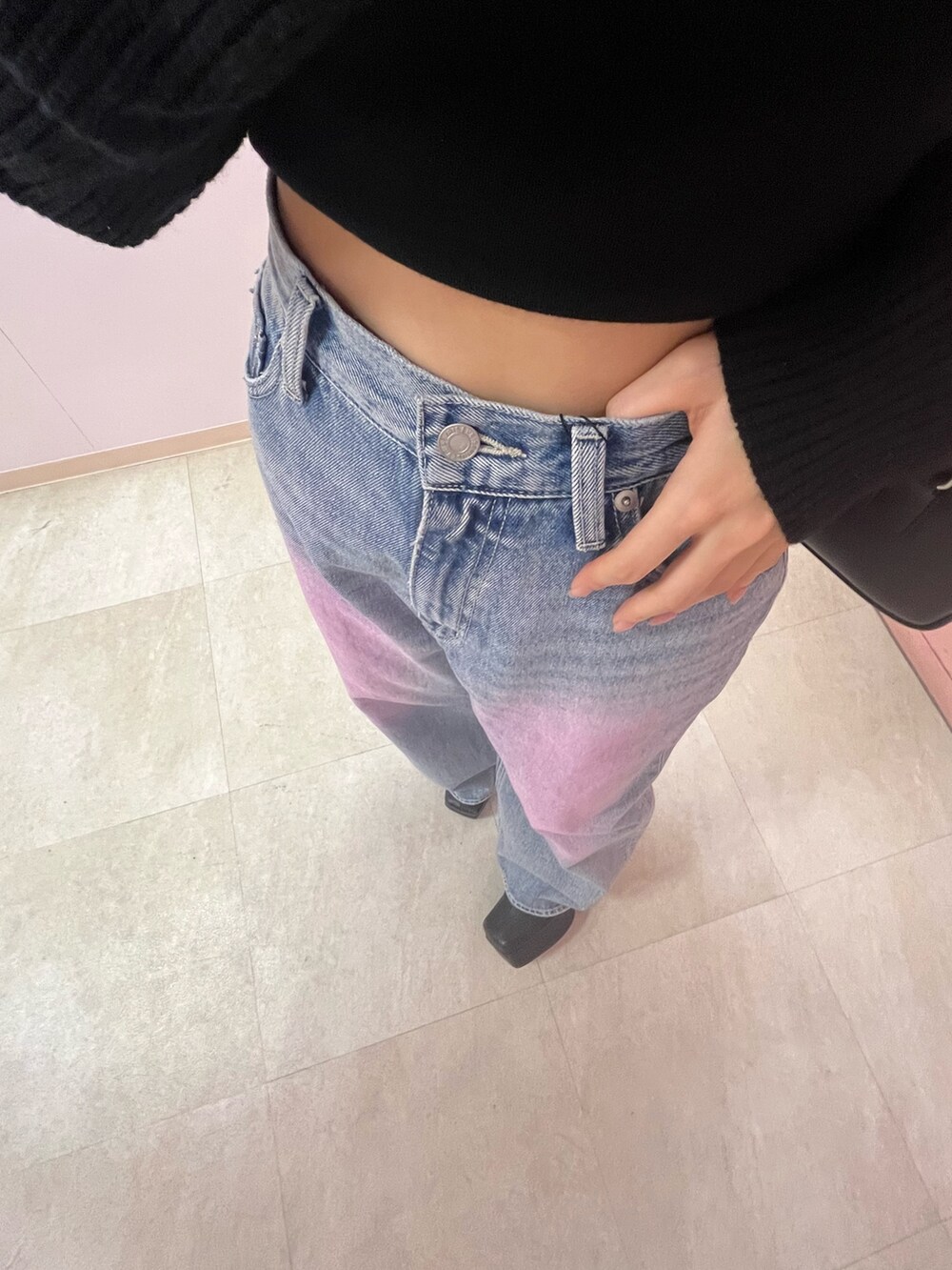 ブラック系のボストンバッグ、ブラック系のブーツ、イエロー系のニット/セーターを着用したレディースの春コーディネートの7枚目の写真