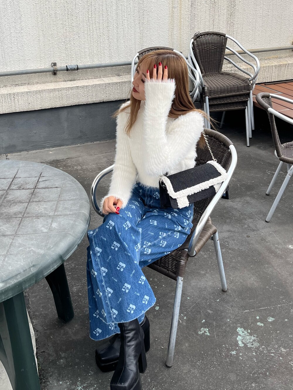 ホワイト系のニット/セーター、ブルー系のデニムパンツ、ブラック系のブーツを着用したレディースの秋コーディネートの6枚目の写真
