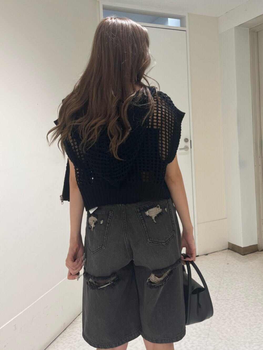 ブラック系のブーツ、ブラック系のハンドバッグ、ブラック系のキャミソールを着用したレディースの夏コーディネートの5枚目の写真