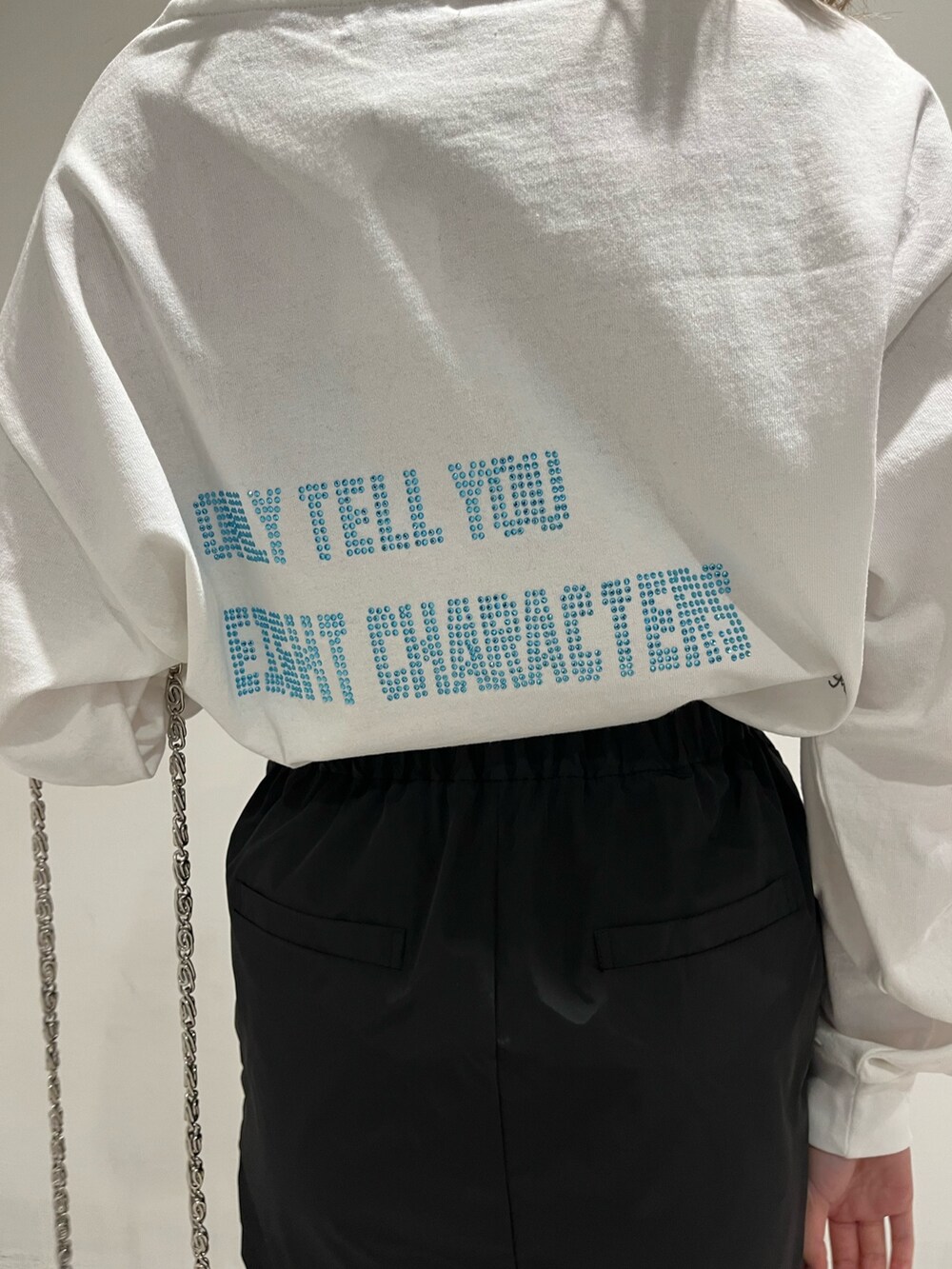 ホワイト系のブーツ、ブルー系のショルダーバッグ、ホワイト系のTシャツ/カットソーを着用したレディースの冬コーディネートの7枚目の写真