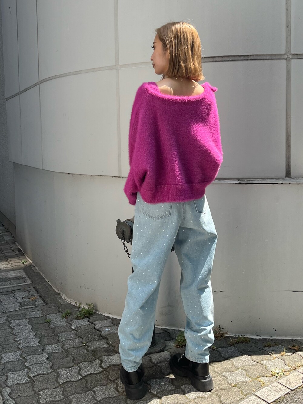 ピンク系のカーディガン/ボレロ、ブルー系のデニムパンツ、ホワイト系のブーツを着用したレディースの秋コーディネートの3枚目の写真