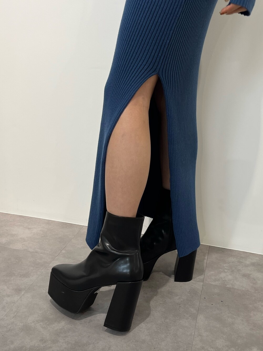 ブラック系のムートンコート、ブルー系のワンピース、ブラック系のブーツを着用したレディースの冬コーディネートの10枚目の写真