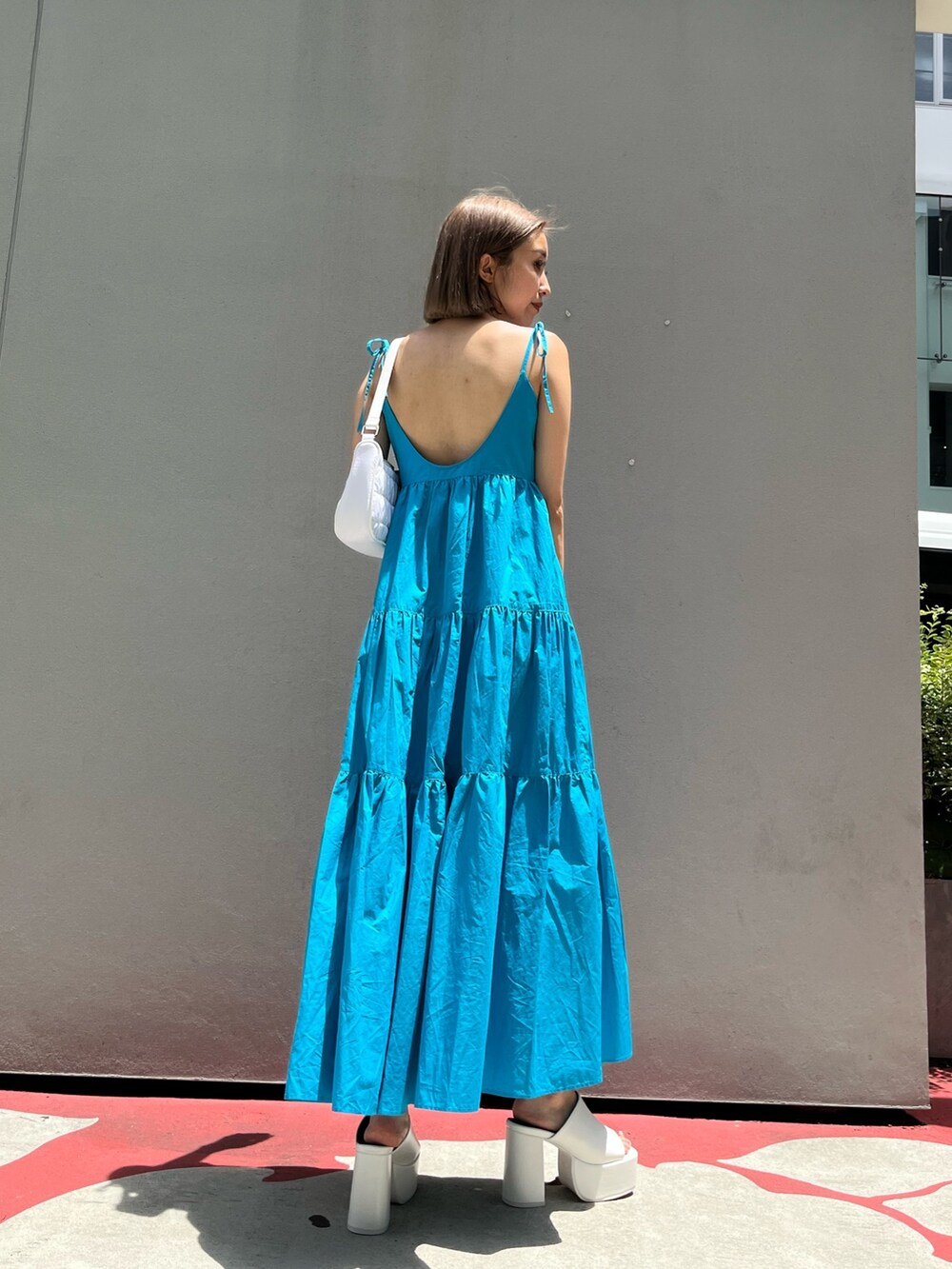 ホワイト系のサンダル、ブラック系のワンピースを着用したレディースの夏コーディネートの7枚目の写真