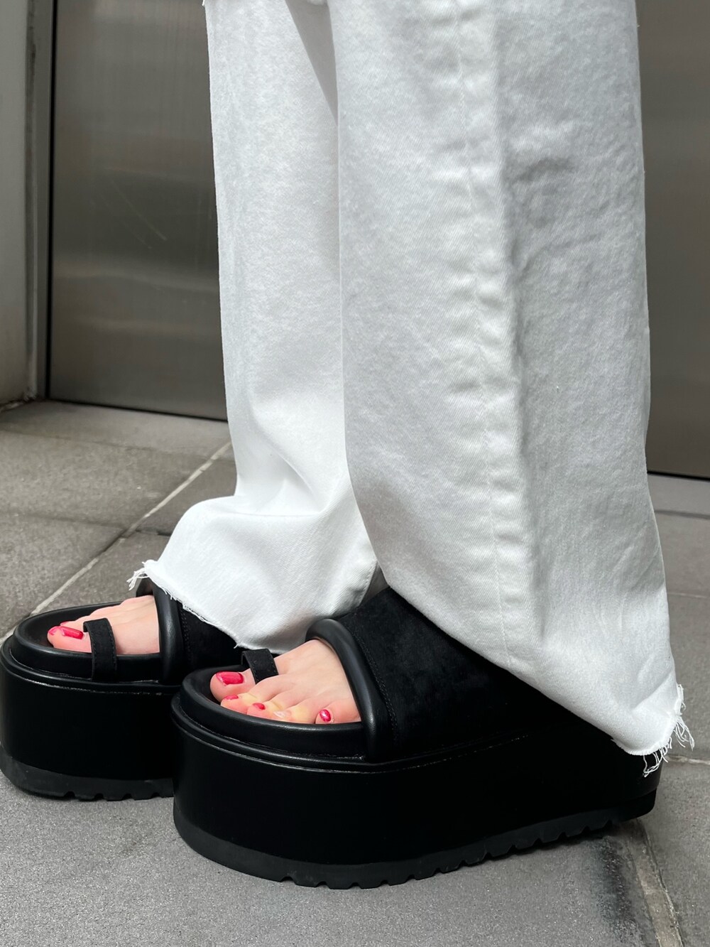 ブラック系のサンダル、ブラック系のミリタリージャケット、オレンジ系のワンピースを着用したレディースの春コーディネートの8枚目の写真