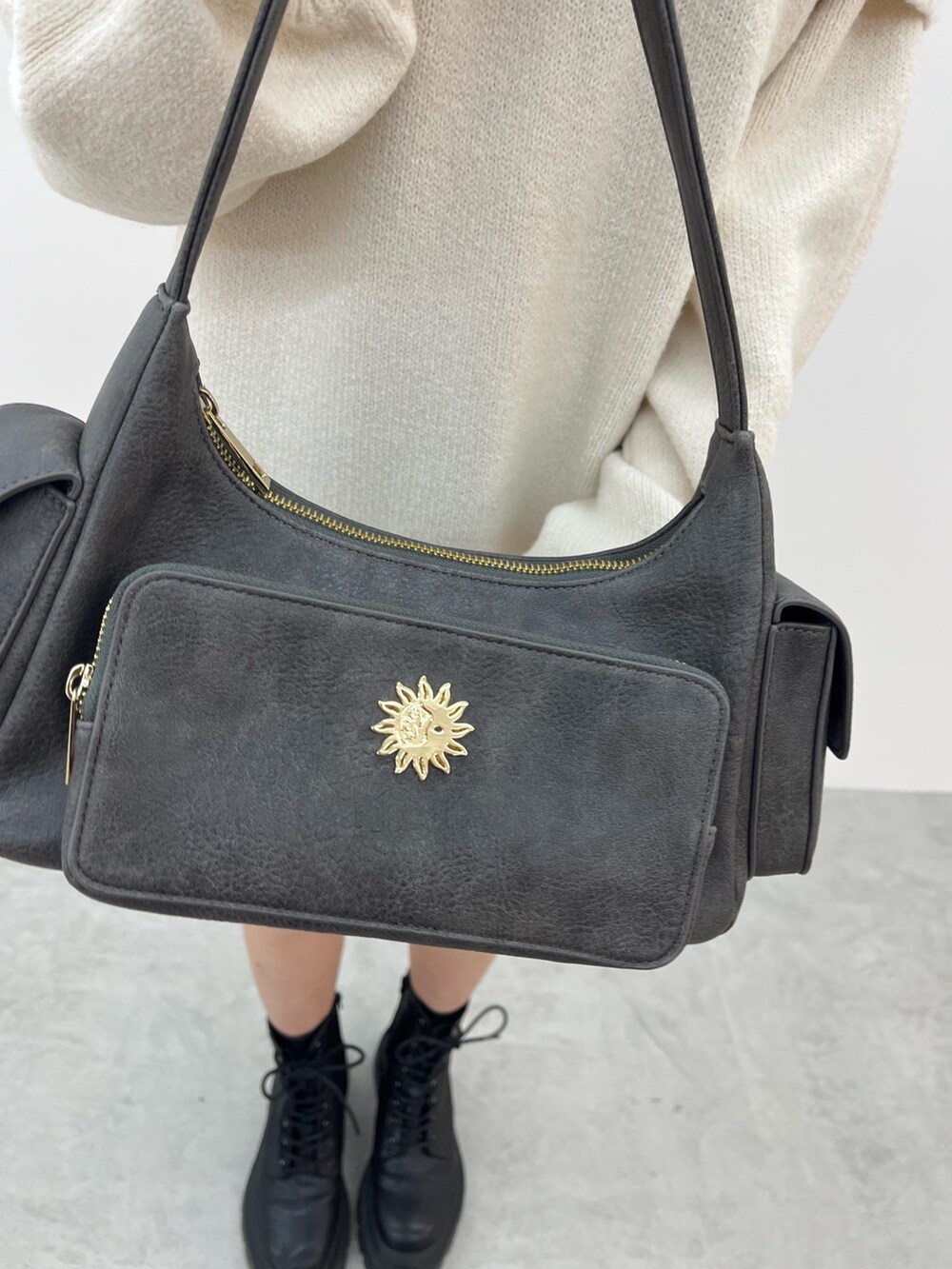 グレー系のハンドバッグ、ホワイト系のワンピース、ブラック系のブーツを着用したレディースの冬コーディネートの6枚目の写真