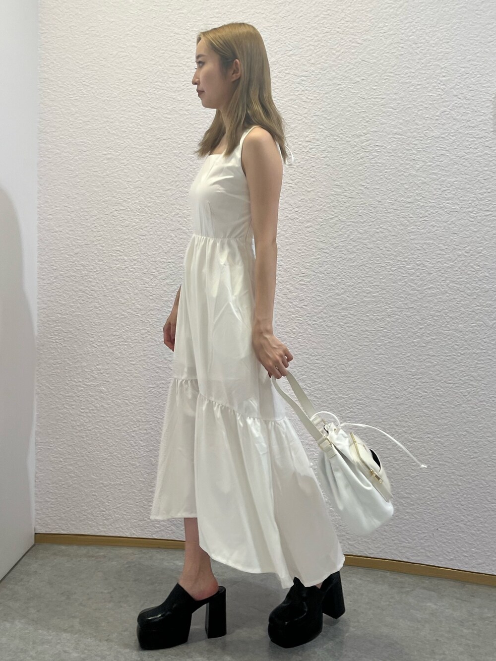 ホワイト系のサンダル、ホワイト系のショルダーバッグ、ホワイト系のワンピースを着用したレディースの夏コーディネートの2枚目の写真