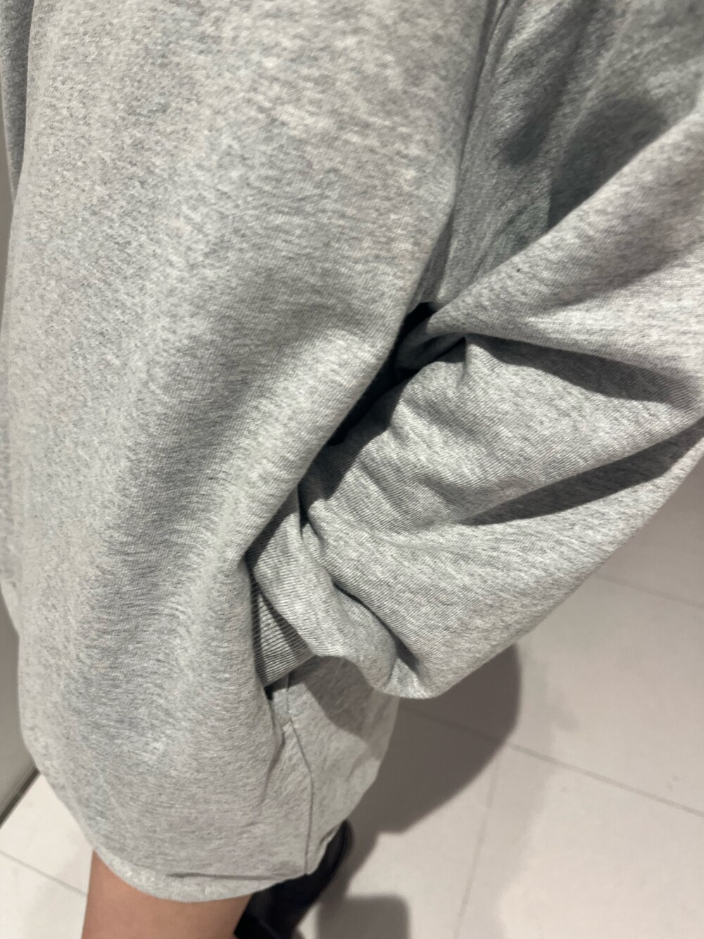 ブラック系のハンドバッグ、グレー系のTシャツ/カットソー、ブラウン系のブーツを着用したレディースの秋コーディネートの6枚目の写真