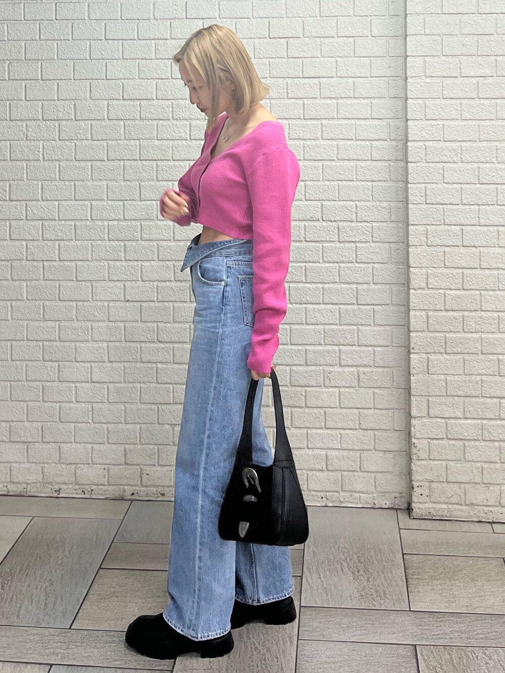 ブルー系のデニムパンツ、ホワイト系のブーツ、ブラック系のハンドバッグを着用したレディースの冬コーディネートの2枚目の写真