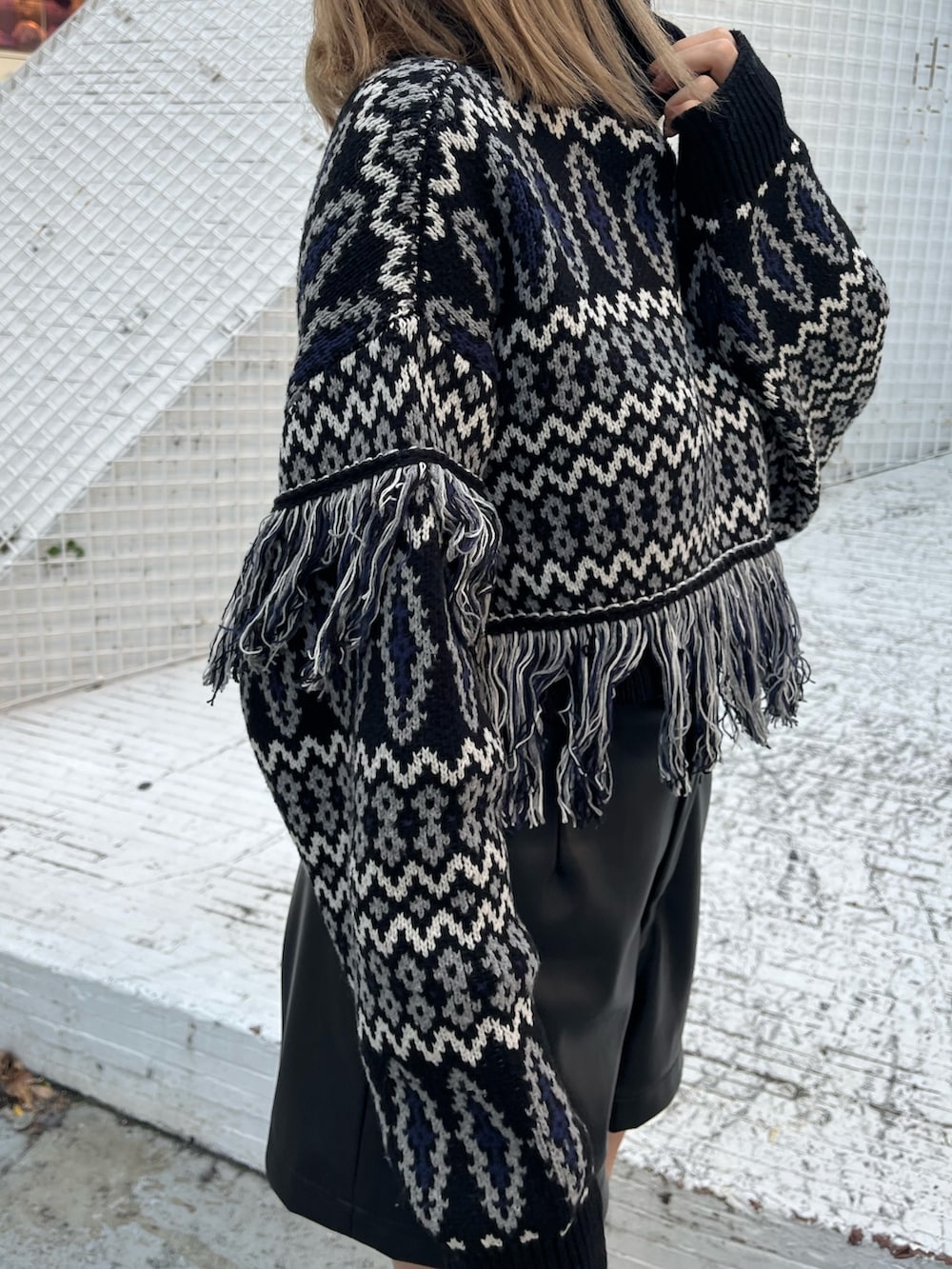 ブラック系のニット/セーター、ベージュ系のその他パンツ、ブラック系のブーツを着用したレディースの冬コーディネートの5枚目の写真