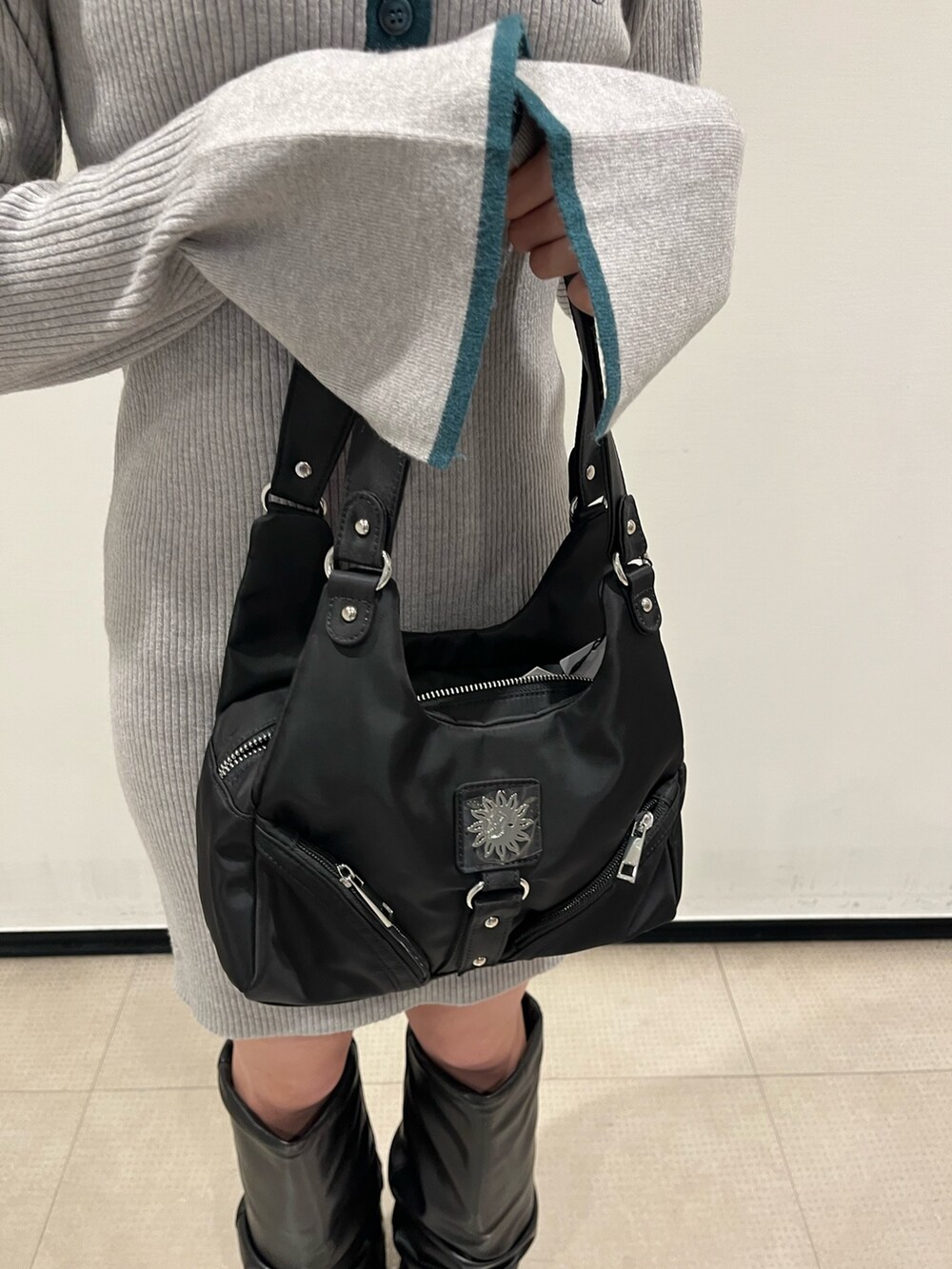 ブラック系のブーツ、グレー系のワンピース、ブラック系のハンドバッグを着用したレディースの冬コーディネートの8枚目の写真