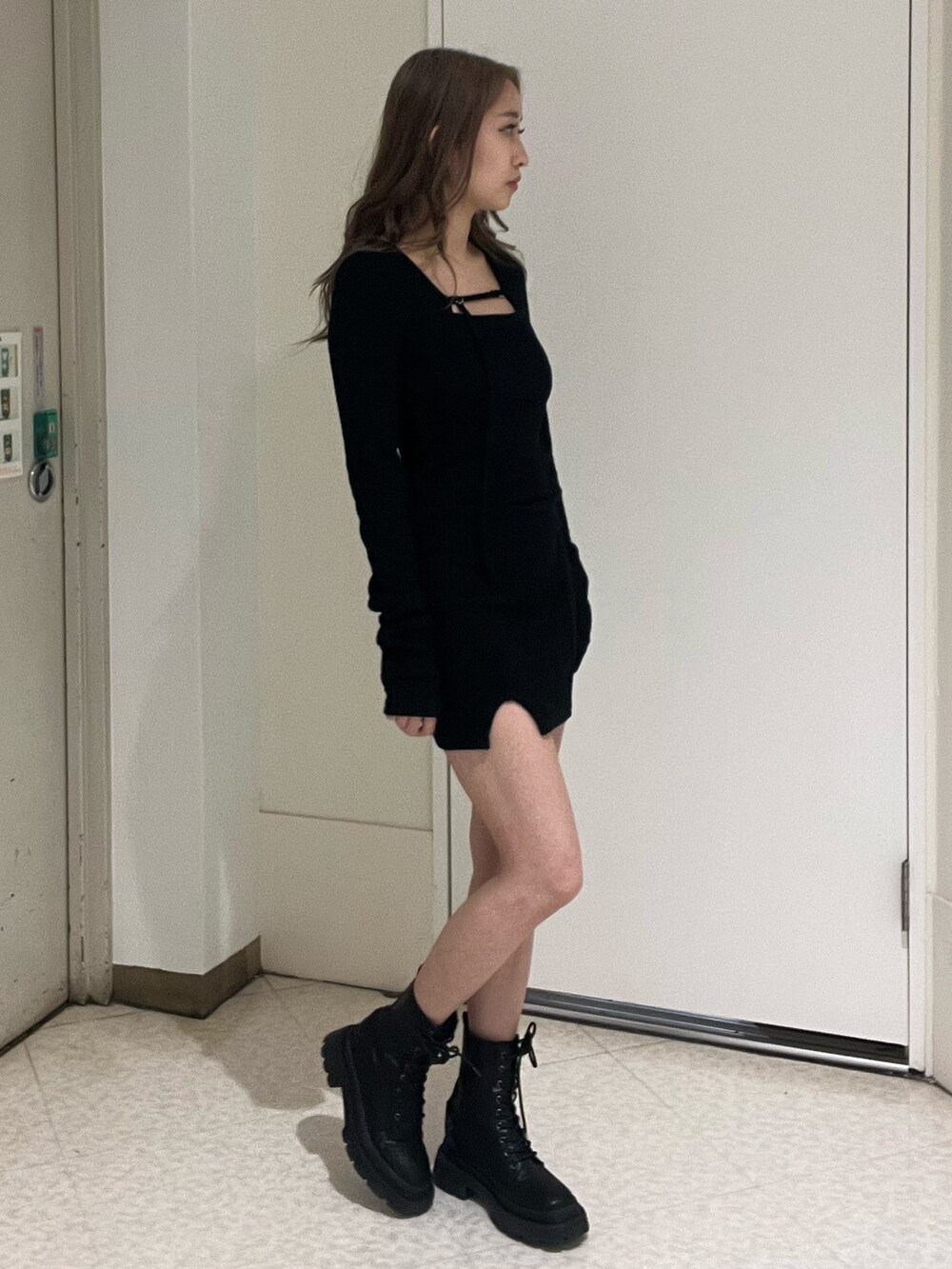 ブラック系のワンピース、ブラック系のブーツを着用したレディースの春コーディネートの2枚目の写真