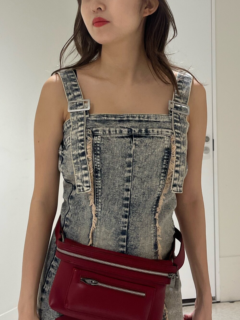 ベージュ系のワンピース、ブラック系のブーツ、レッド系のショルダーバッグを着用したレディースの夏コーディネートの4枚目の写真