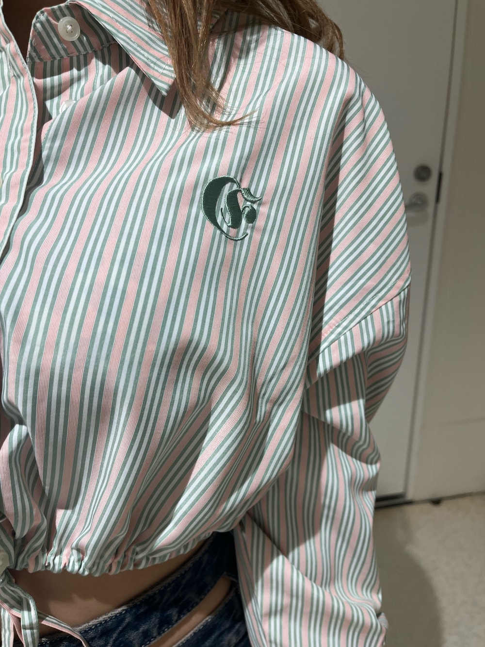 ブルー系のシャツ/ブラウス、ブルー系のデニムパンツ、ブラック系のブーツを着用したレディースの春コーディネートの5枚目の写真