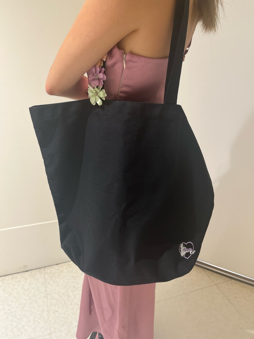 ピンク系のワンピース、ブラック系のトートバッグ、シルバー系のブーツを着用したレディースの夏コーディネートの5枚目の写真