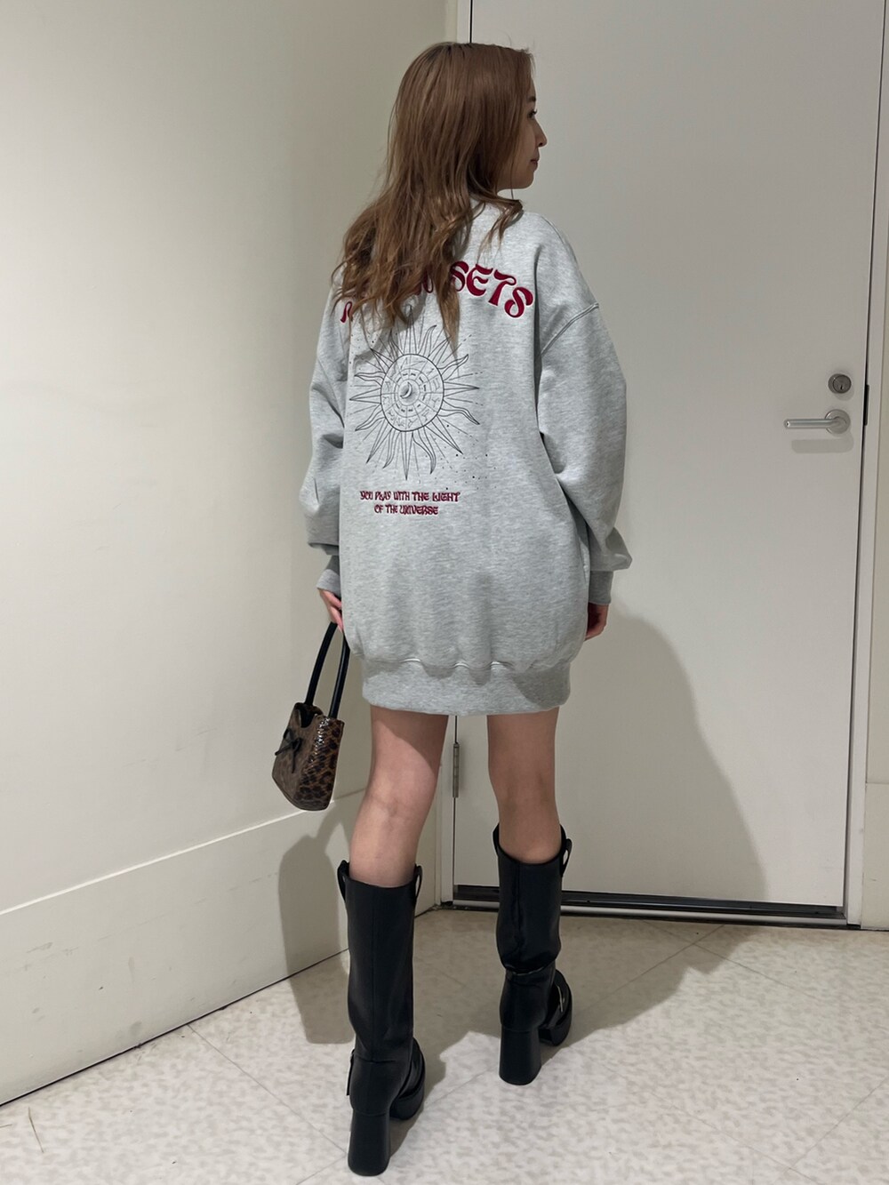 ブラック系のブーツ、ブラウン系のハンドバッグ、グレー系のスウェットを着用したレディースの春コーディネートの3枚目の写真