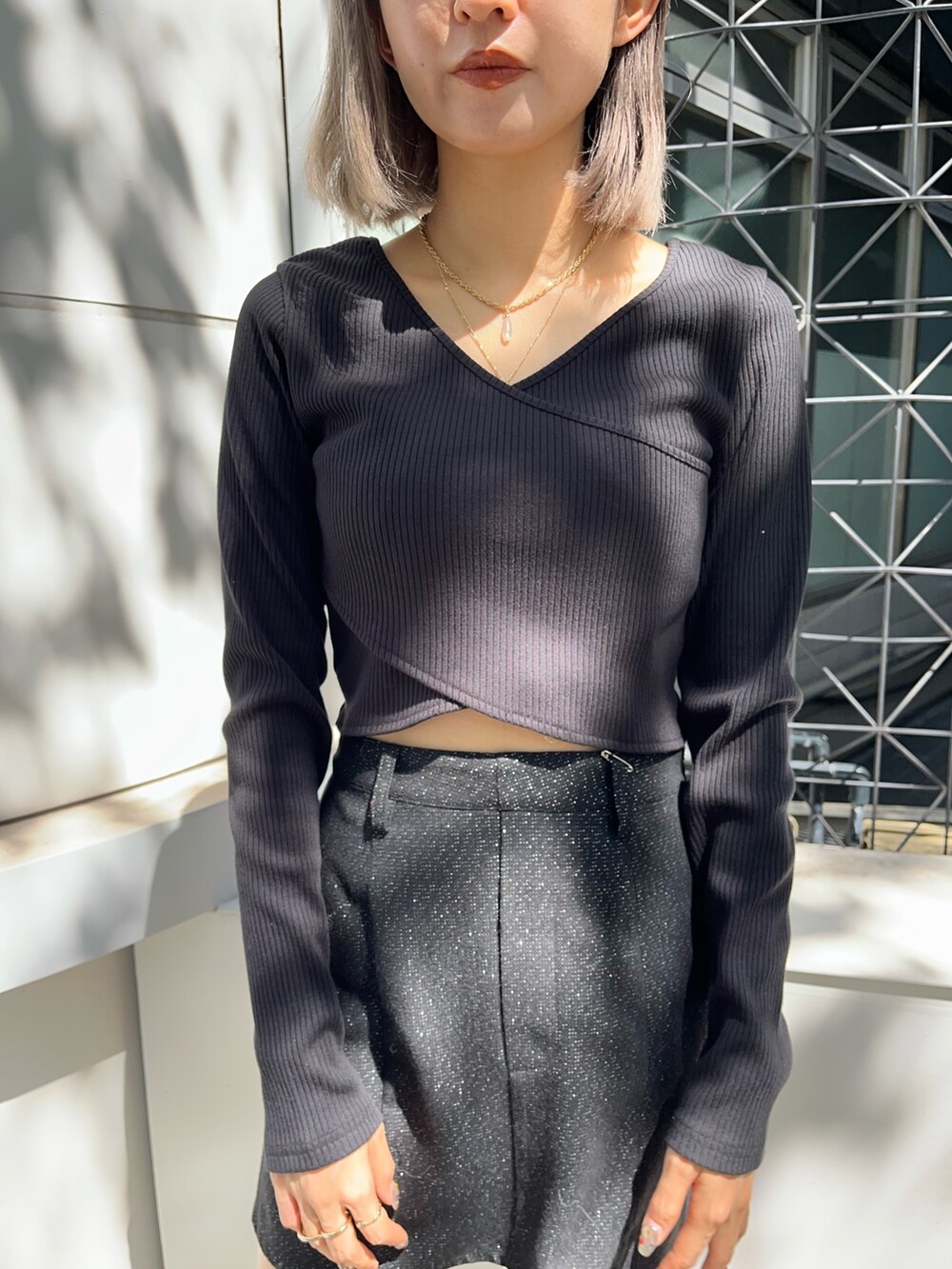 ブラック系のテーラードジャケット、ブラック系のスカート、ブラック系のブーツを着用したレディースの秋コーディネートの7枚目の写真