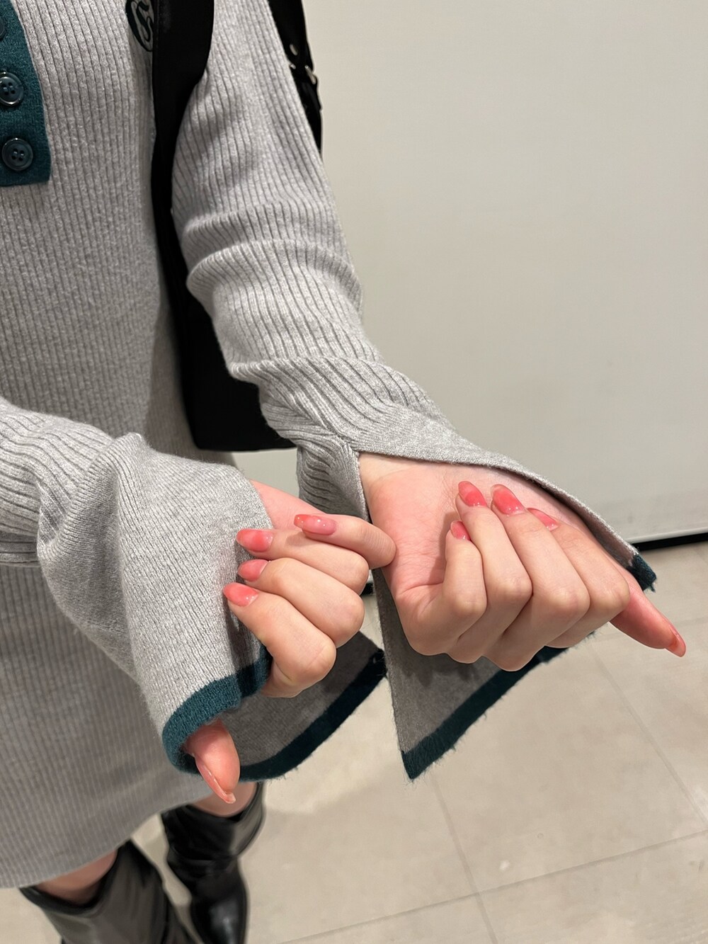 ブラック系のブーツ、グレー系のワンピース、ブラック系のハンドバッグを着用したレディースの冬コーディネートの6枚目の写真