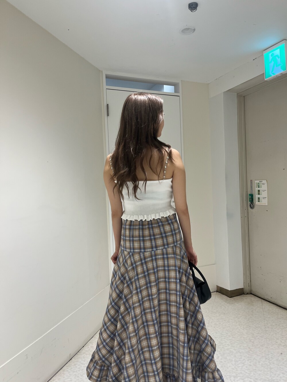 グレー系のスカート、レッド系のキャミソール、ブラック系のハンドバッグを着用したレディースの夏コーディネートの6枚目の写真