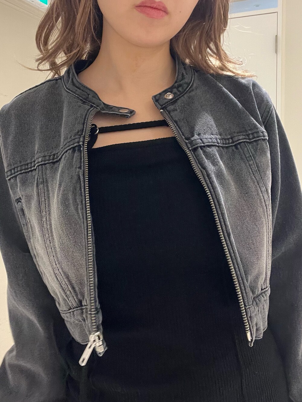 ブルー系のデニムジャケット、ブラック系のワンピース、ブラック系のブーツを着用したレディースの春コーディネートの4枚目の写真