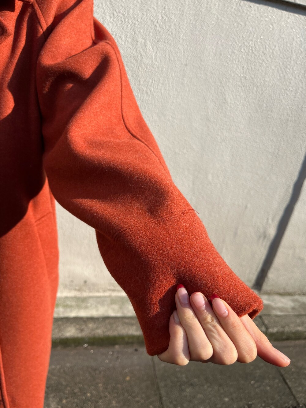 ブラック系のワンピース、オレンジ系のその他アウター、ブラック系のショルダーバッグを着用したレディースの冬コーディネートの6枚目の写真