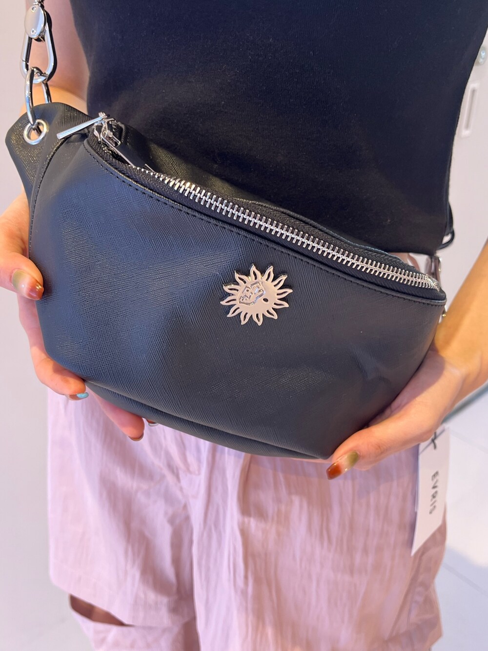 ピンク系のカーゴパンツ、シルバー系のボディバッグ/ウエストポーチ、ブラック系のTシャツ/カットソーを着用したレディースの春コーディネートの5枚目の写真