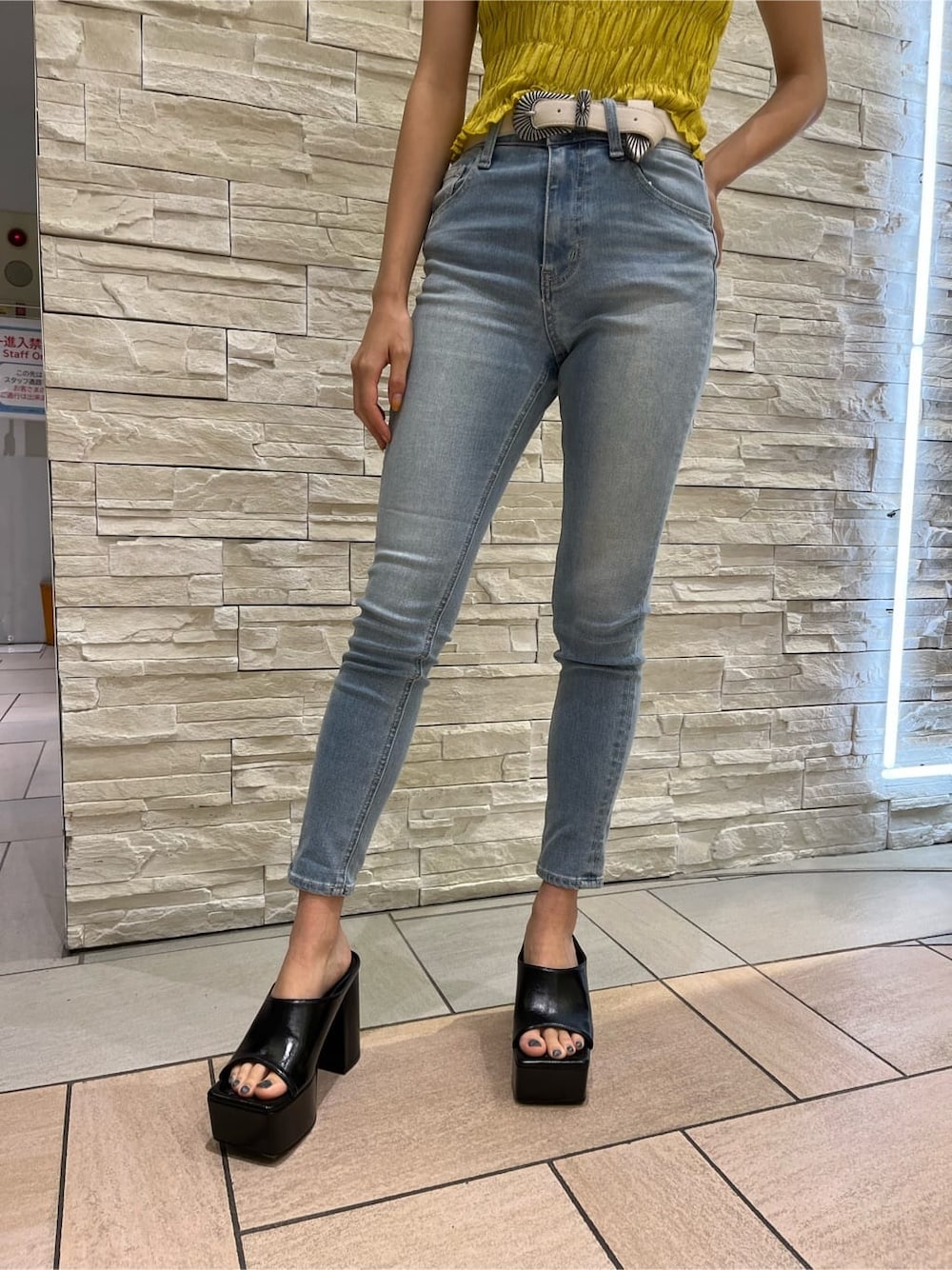 イエロー系のシャツ/ブラウス、ブラック系のサンダル、ブルー系のデニムパンツを着用したレディースの夏コーディネートの5枚目の写真