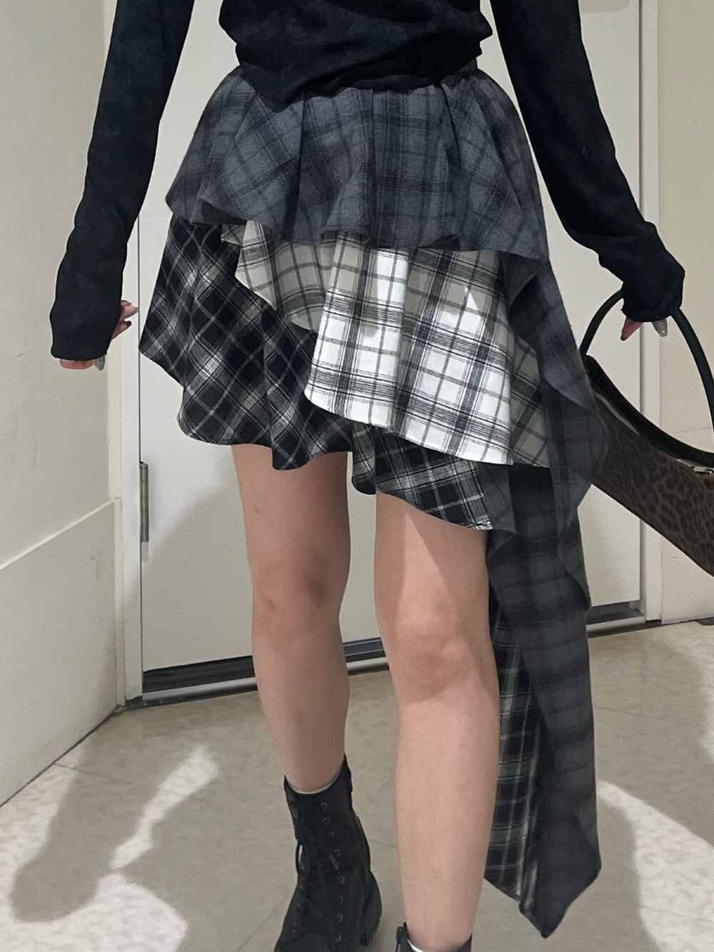 ブラウン系のハンドバッグ、ブラック系のブーツ、ブラック系のTシャツ/カットソーを着用したレディースの春コーディネートの6枚目の写真