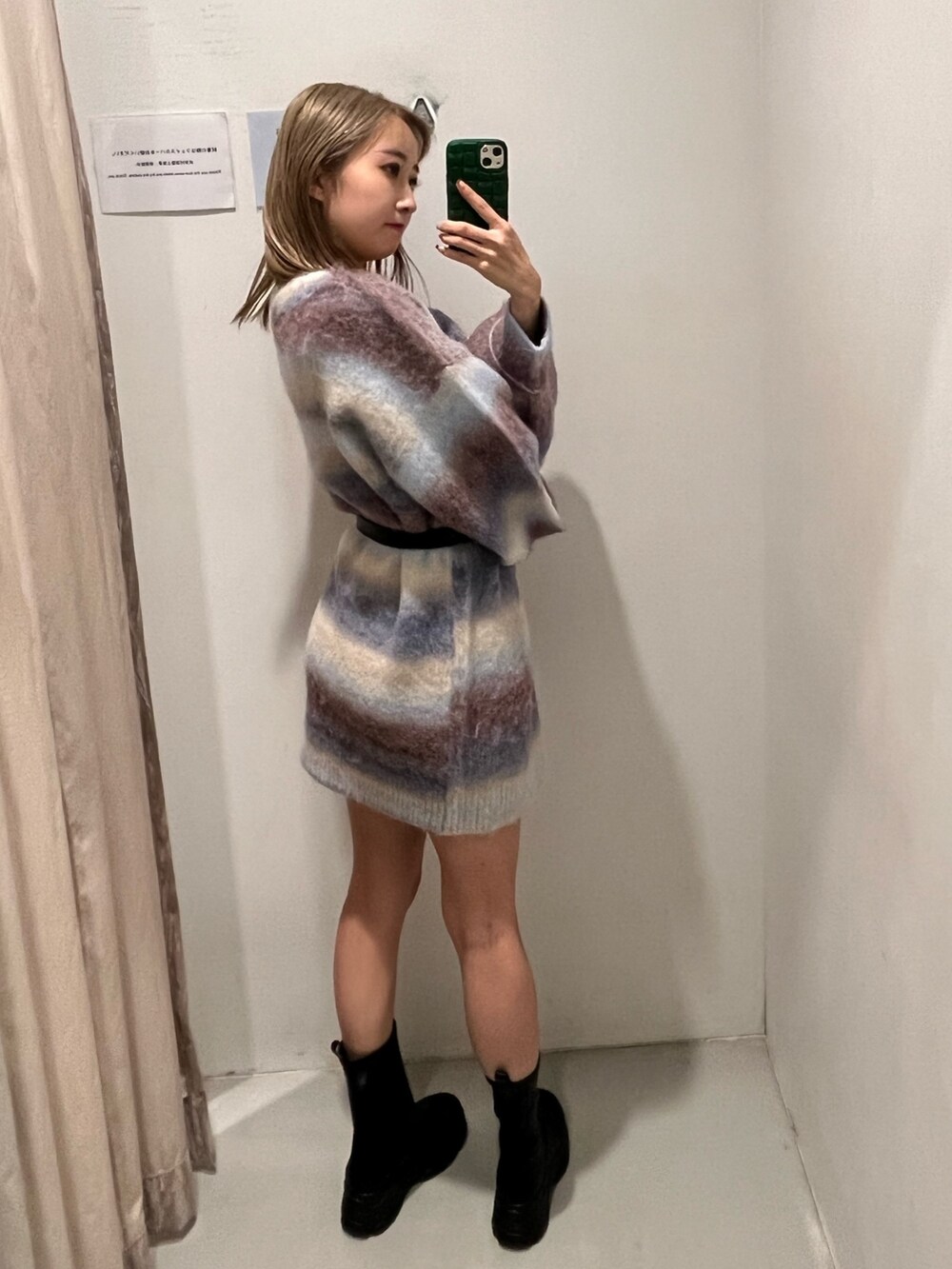 パープル系のニット/セーター、ブラック系のブーツ、ブラック系のベルトを着用したレディースの冬コーディネートの7枚目の写真