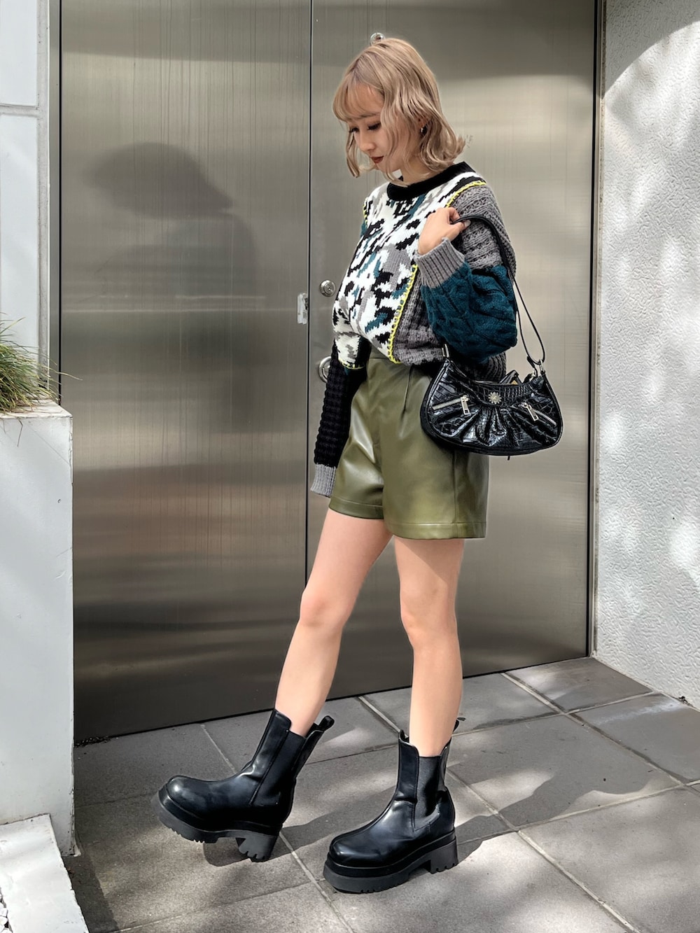 ホワイト系のブーツ、ブラック系のショルダーバッグ、ブラック系のニット/セーターを着用したレディースの秋コーディネートの4枚目の写真