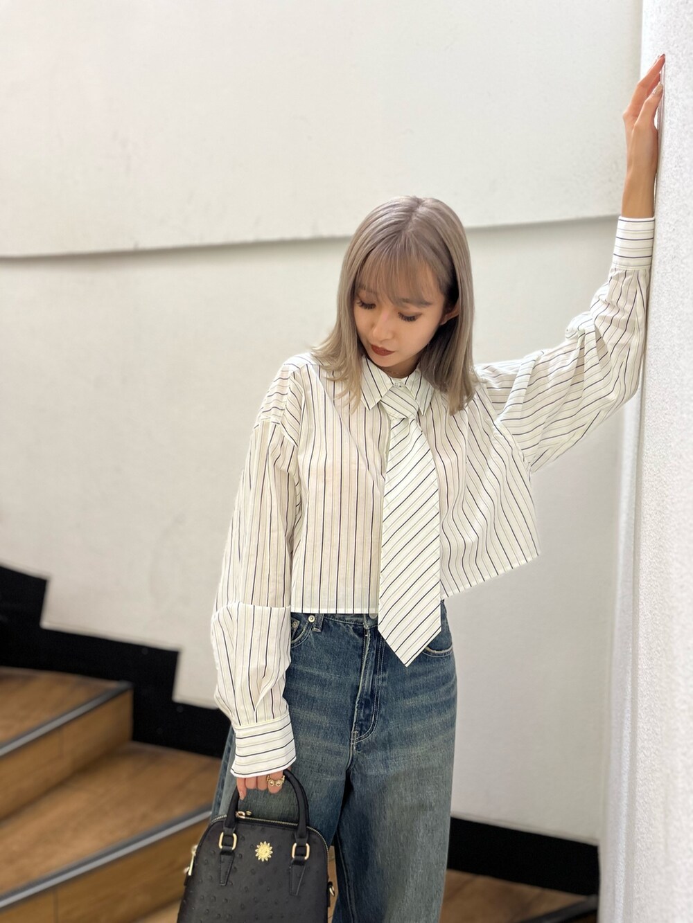 ブラック系のショルダーバッグ、ブラック系のブーツ、ホワイト系のシャツ/ブラウスを着用したレディースの冬コーディネートの5枚目の写真