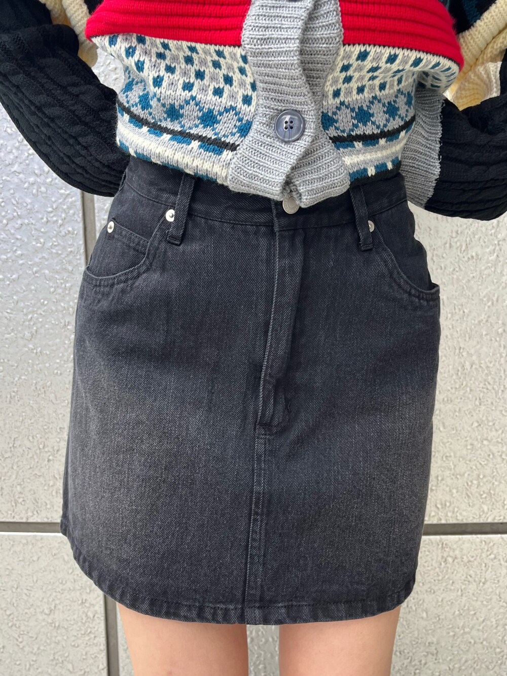 ブラック系のブーツ、ブラック系のデニムスカート、ブルー系のニット/セーターを着用したレディースの秋コーディネートの5枚目の写真
