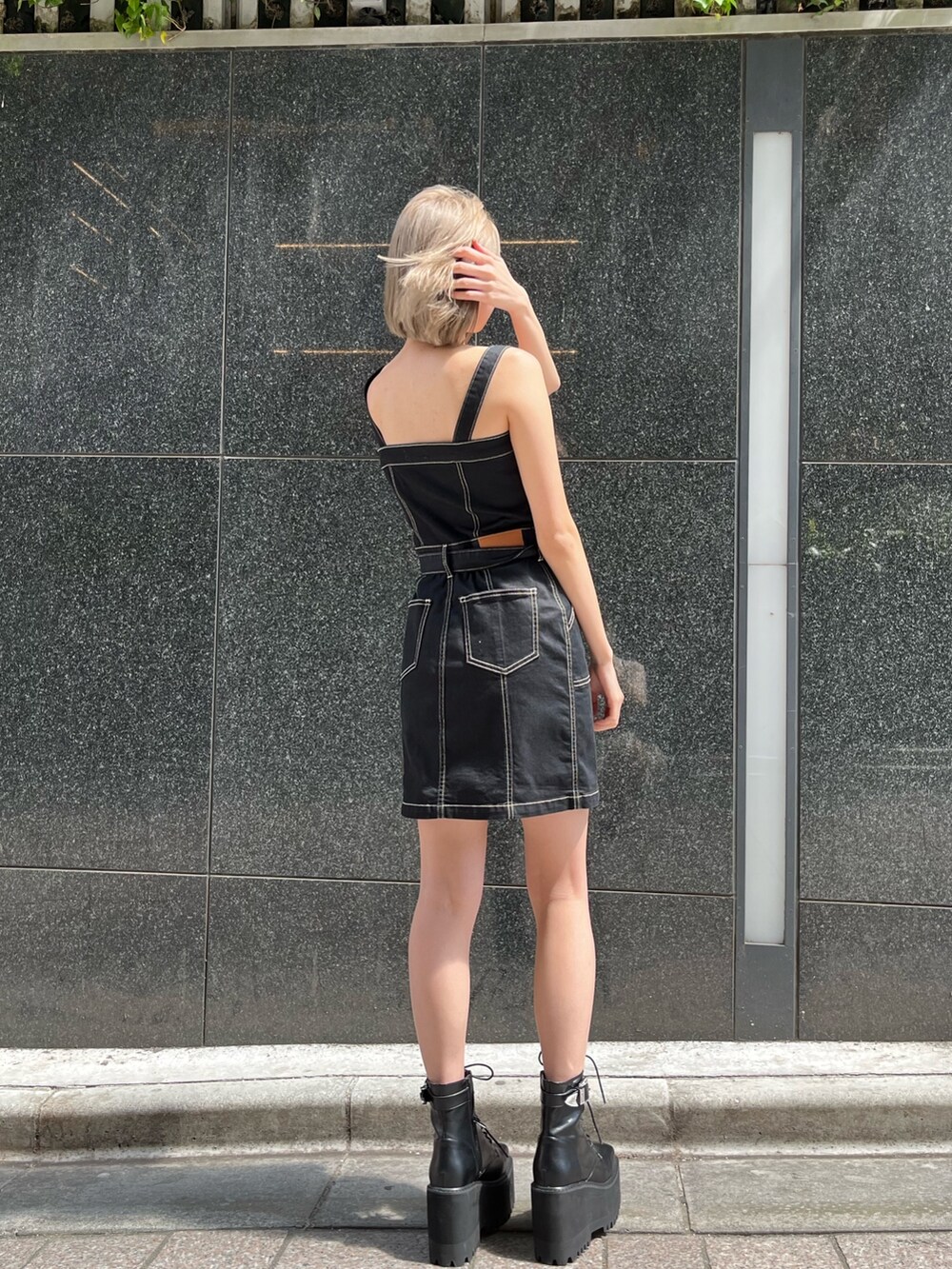 ブラック系のブーツ、ブラック系のジャンパースカートを着用したレディースの春コーディネートの4枚目の写真