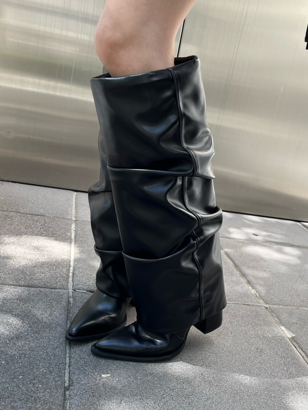 ブラック系のブーツ、グレー系のワンピース、ブラック系のハンドバッグを着用したレディースの冬コーディネートの9枚目の写真