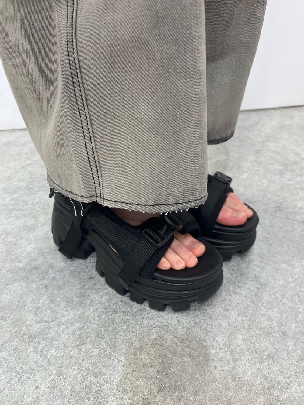 シルバー系のショルダーバッグ、ブラック系のキャミソール、ブラック系のデニムパンツを着用したレディースの夏コーディネートの9枚目の写真