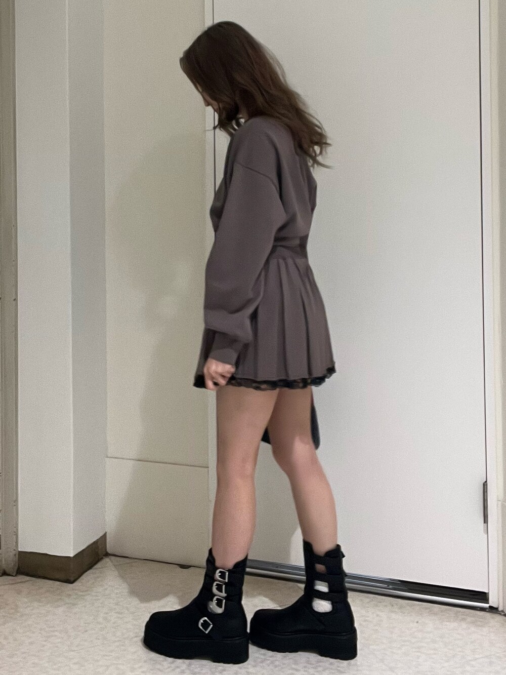 ブラック系のスウェット、ブラック系のスカート、ブラウン系のハンドバッグを着用したレディースの春コーディネートの4枚目の写真