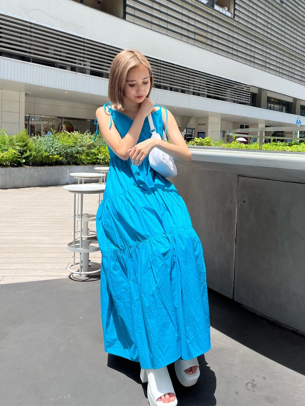 ホワイト系のサンダル、ブラック系のワンピースを着用したレディースの夏コーディネートの6枚目の写真