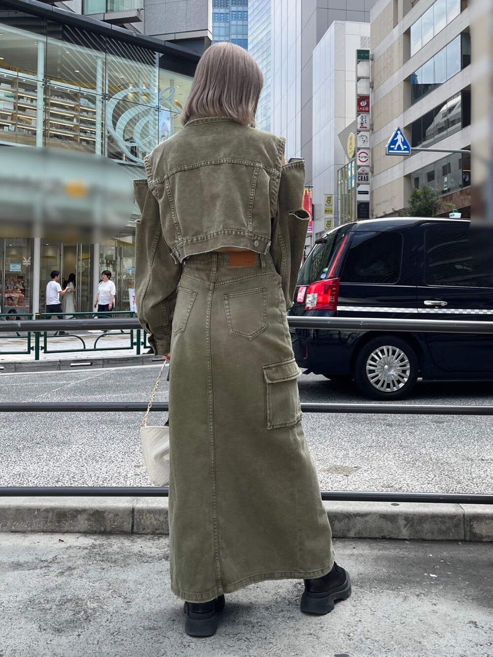 グリーン系のデニムジャケット、グリーン系のデニムスカート、ブラック系のハンドバッグを着用したレディースの秋コーディネートの5枚目の写真