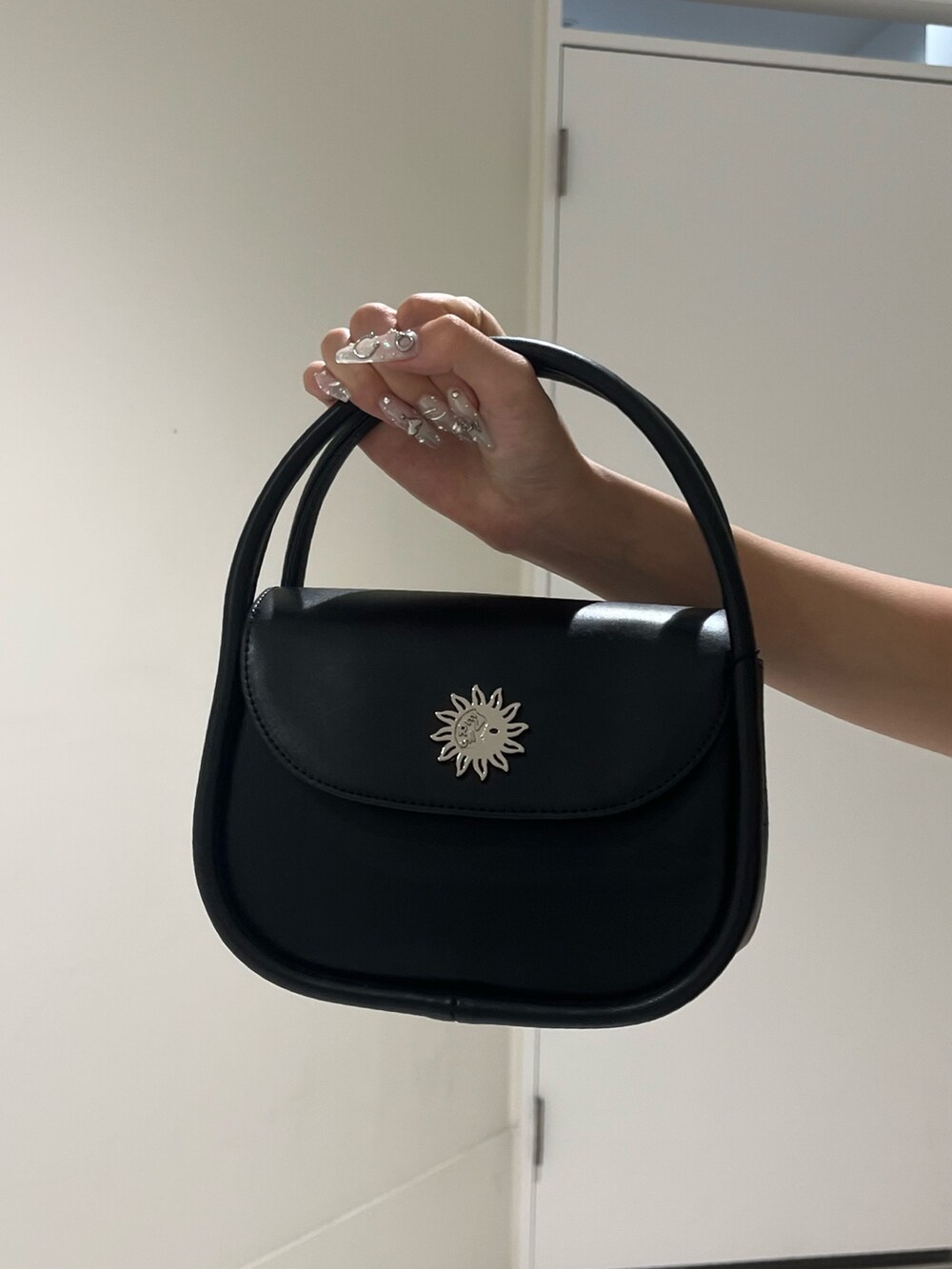 ブルー系のデニムパンツ、ブラック系のハンドバッグ、ブラック系のサンダルを着用したレディースの夏コーディネートの6枚目の写真