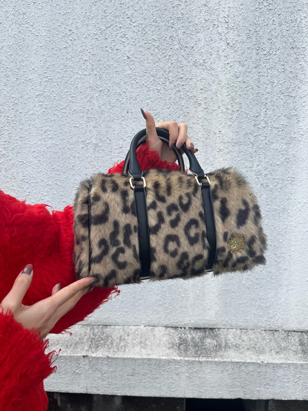 ブラック系のブーツ、レッド系のニット/セーター、ブルー系のデニムパンツを着用したレディースの冬コーディネートの5枚目の写真