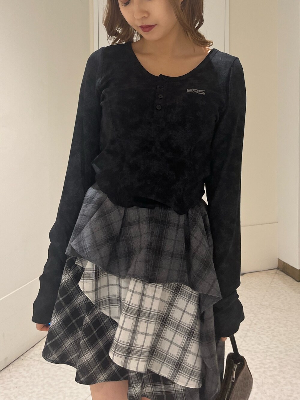 ブラウン系のハンドバッグ、ブラック系のブーツ、ブラック系のTシャツ/カットソーを着用したレディースの春コーディネートの4枚目の写真