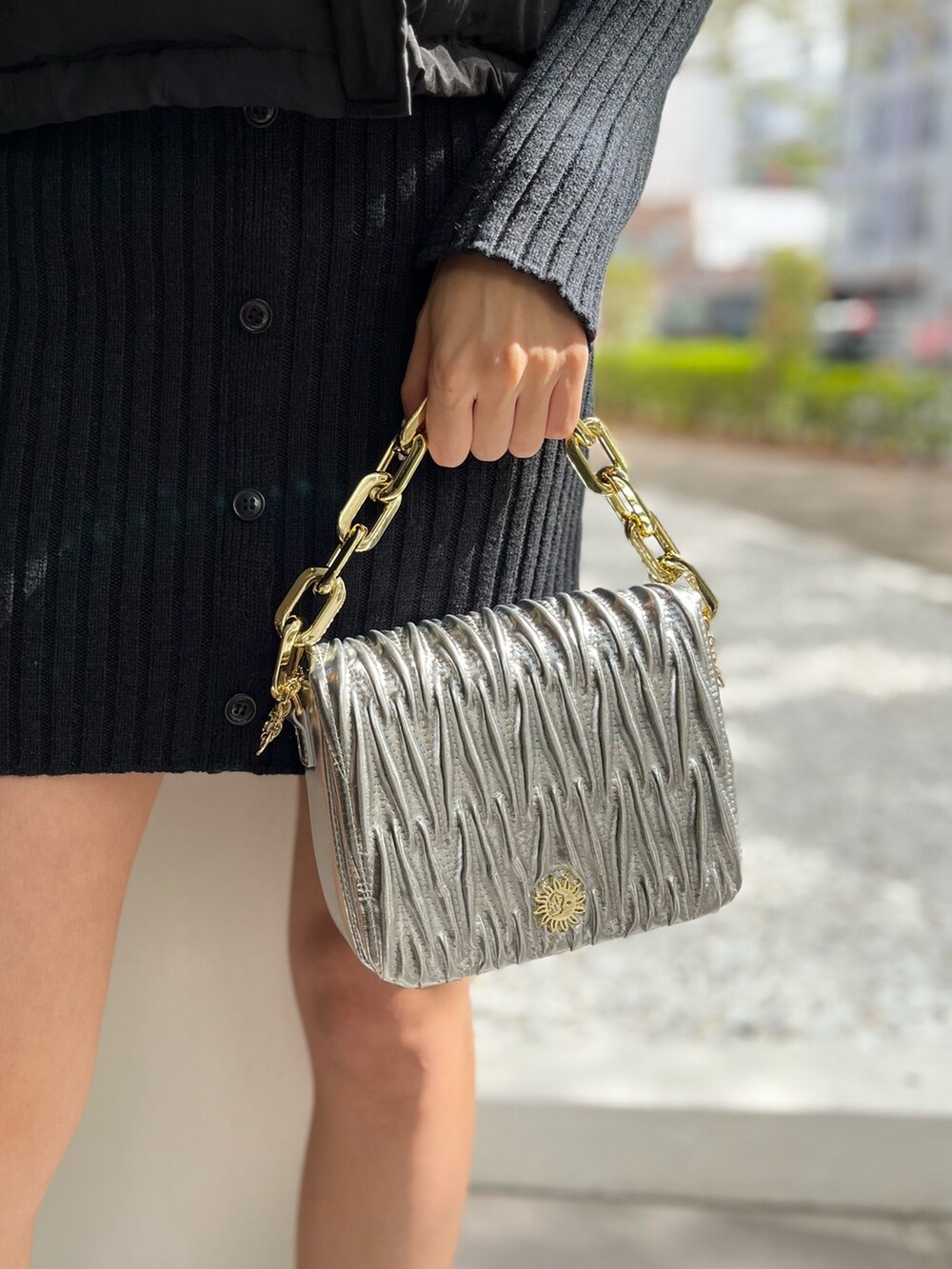 ブラック系のワンピース、シルバー系のショルダーバッグ、ホワイト系のブーツを着用したレディースの秋コーディネートの5枚目の写真