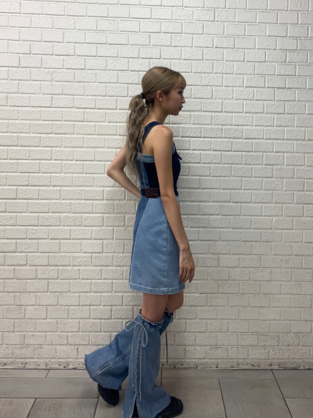 ブルー系のワンピース、ブラック系のブーツ、ブルー系のレッグウォーマーを着用したレディースの夏コーディネートの2枚目の写真