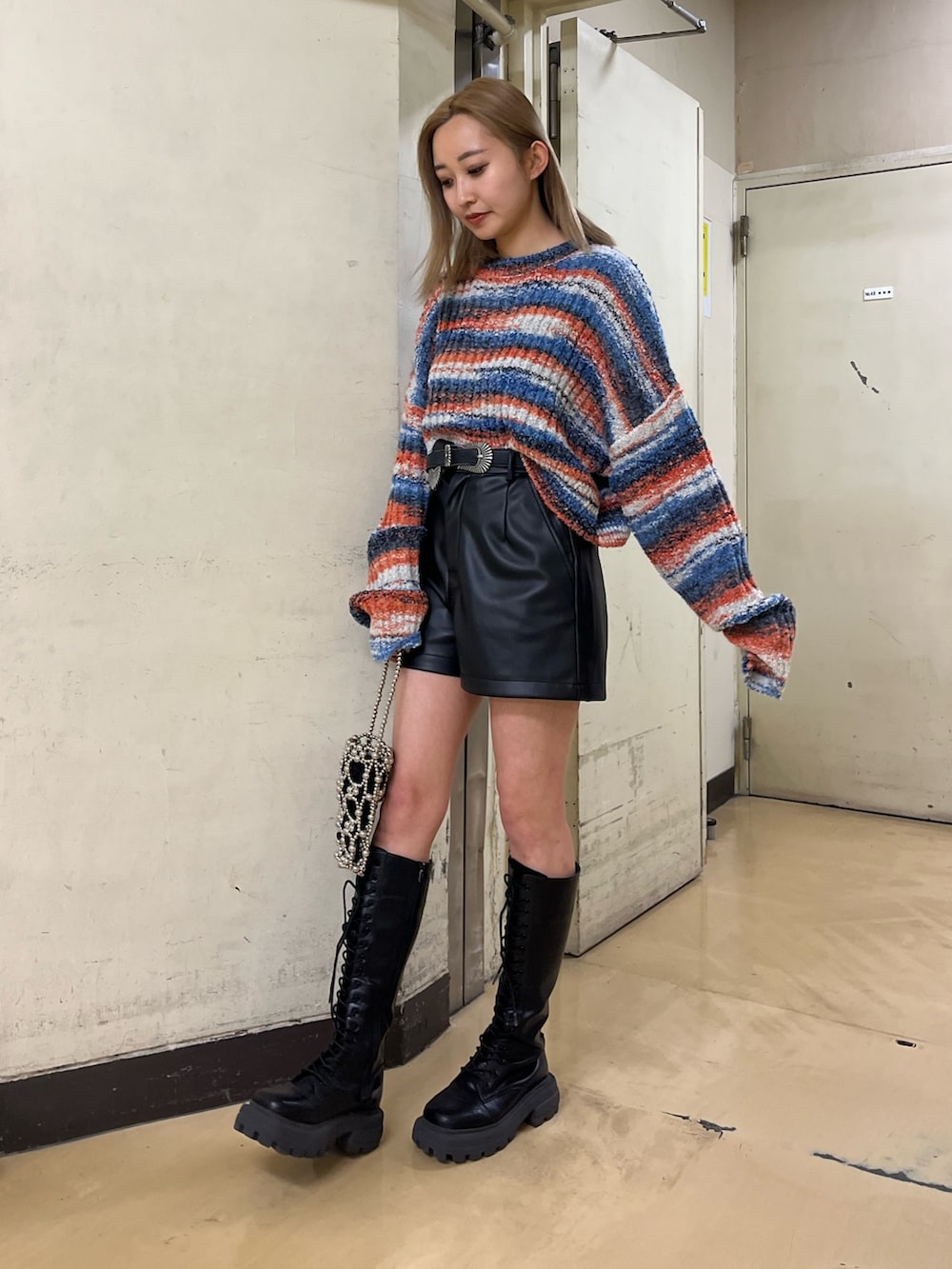 ベージュ系のその他パンツ、ブラック系のブーツ、ブラック系のベルトを着用したレディースの冬コーディネートの2枚目の写真