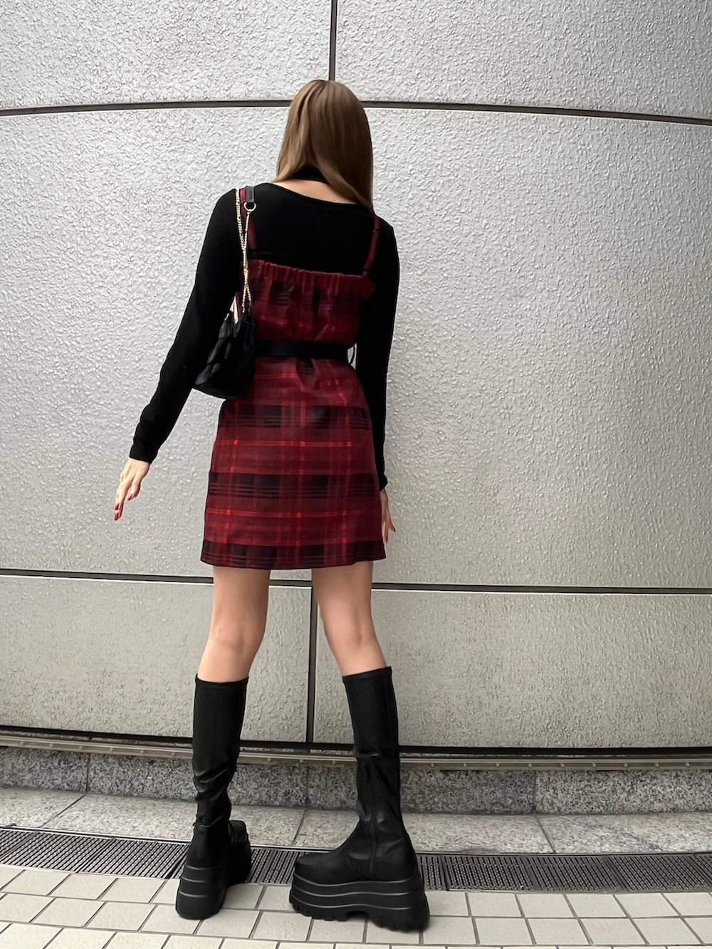 ブラック系のTシャツ/カットソー、レッド系のワンピース、ブラック系のブーツを着用したレディースの秋コーディネートの3枚目の写真